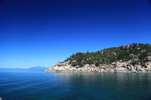 an island in the middle of a body of water at Serenity in Picnic Bay