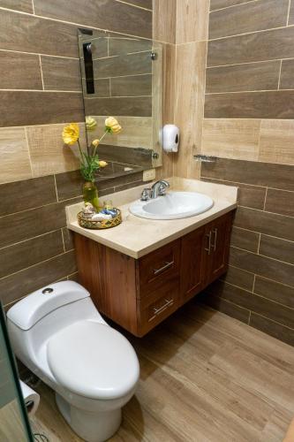 a bathroom with a toilet and a sink at Villa Rosalía Jarabacoa con Piscina Climatizada in Jarabacoa
