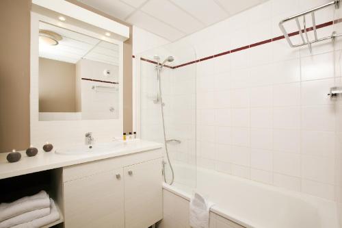 a white bathroom with a shower and a sink at Residhome Toulouse Occitania in Toulouse