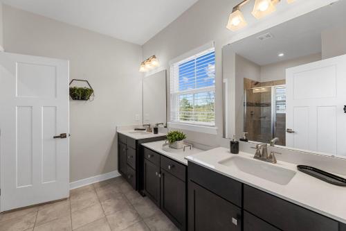 a bathroom with two sinks and a window at New 4 Bedroom Townhouse at Barefoot Resort in North Myrtle Beach