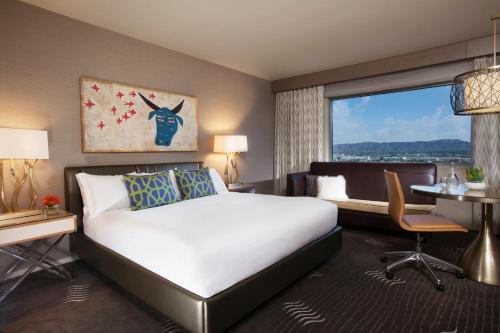 a hotel room with a bed and a desk and a window at Kimpton Hotel Palomar Phoenix Cityscape, an IHG Hotel in Phoenix