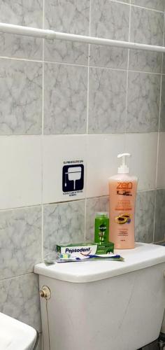 a bathroom with a toilet and a bottle of toothpaste at Tatai Kumang Homestay in Kuching