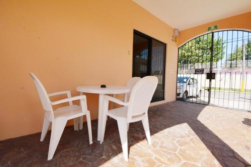 een witte tafel en stoelen in een kamer met een raam bij Coral Island Suites Cozumel in Cozumel
