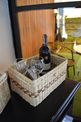 a basket with a bottle of wine and glasses on a table at GLAMPING CAFETOS in Montenegro