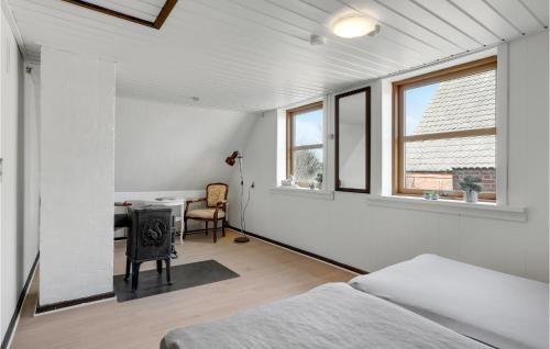 a bedroom with a bed and a desk and windows at Lovely Home In Aakirkeby With Kitchen in Vester Sømarken