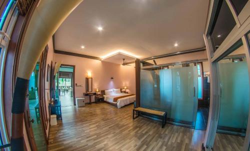 a hotel room with a bed and a room with atained at The Sanctuary Langkawi in Pantai Cenang