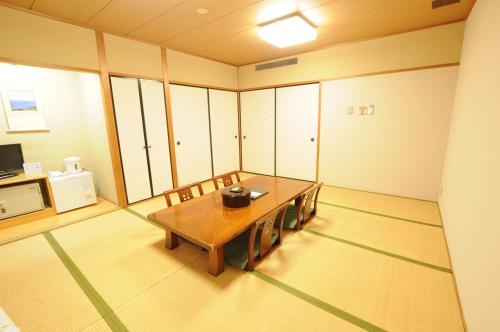 Habitación grande con mesa de madera y sillas. en Isawa no Sato, en Shiso
