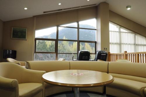 a waiting room with a couch and chairs and a table at Isawa no Sato in Shiso