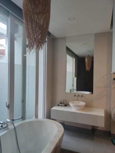 a bathroom with a tub and a sink and a mirror at Morden Bathtub Apartment in Ho Chi Minh City
