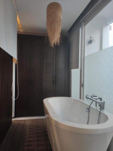 a bathroom with a white tub and a glass shower at Morden Bathtub Apartment in Ho Chi Minh City