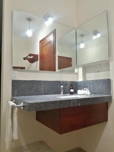a bathroom with a sink and a large mirror at La Morada, una ventana al golfo - Hotel boutique in Monte Gordo