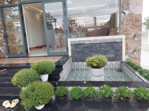 a set of stairs with potted plants in front of a building at Khách sạn AN THỊNH 2 in Doc Let