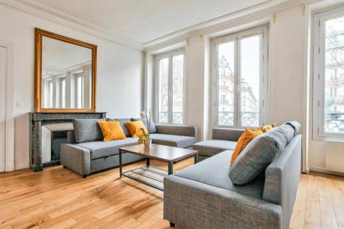 a living room with two couches and a fireplace at Appartement Quartier Le Marais 2 in Paris