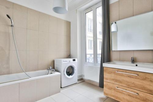 ein Badezimmer mit einer Waschmaschine und einer Waschmaschine in der Unterkunft Appartement Quartier Le Marais 2 in Paris