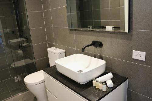 a bathroom with a sink and a toilet at Kooii Apartments in Brisbane