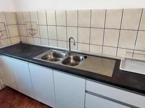 a kitchen with a sink and a black counter top at Comfortable holiday home with a private garden, 200 sqm, 5 bedrooms, Dar owo in Darłowo