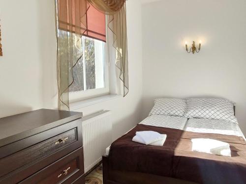 a small bedroom with a bed and a window at Holiday Home Dar owo near Beach & Lighthouse in Darłowo