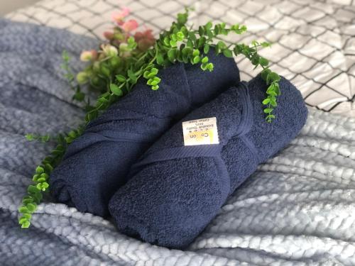 a pair of blue socks with a plant on a bed at Horizon Suites Near KLIA Airport (B) in Sepang