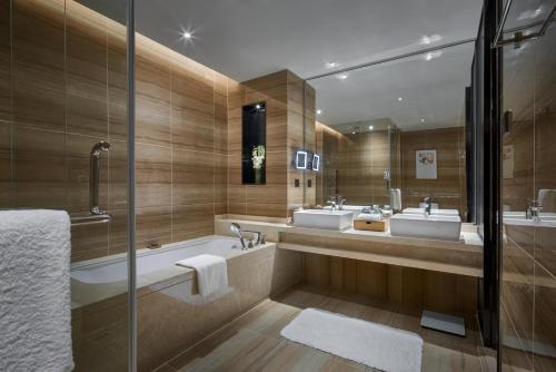 uma casa de banho com 2 lavatórios e uma banheira em Primus Residence Shanghai Hongqiao em Xangai