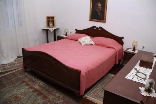 - une chambre avec un grand lit et une couverture rouge dans l'établissement Apartments Frano, à Mirce