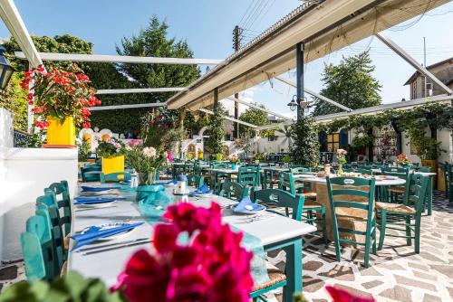 eine Terrasse mit Tischen, Stühlen und Blumen in der Unterkunft Hotel Restaurant Syrtaki in Gernsbach