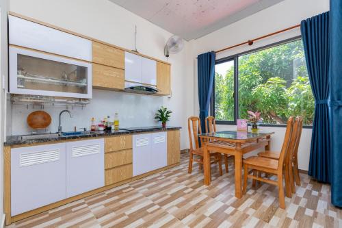 a kitchen and dining room with a table and chairs at MTV Homestay Vũng Tàu in Vung Tau