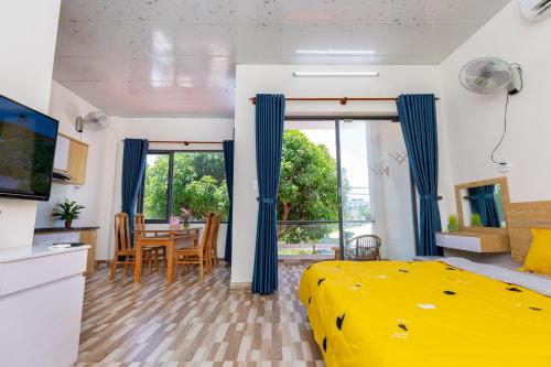 a bedroom with a yellow bed and a dining room at MTV Homestay Vũng Tàu in Vung Tau