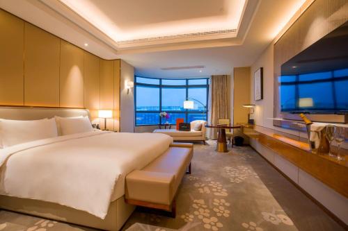a bedroom with a large bed and a large window at Landison Plaza HSD Hotel Hangzhou in Hangzhou