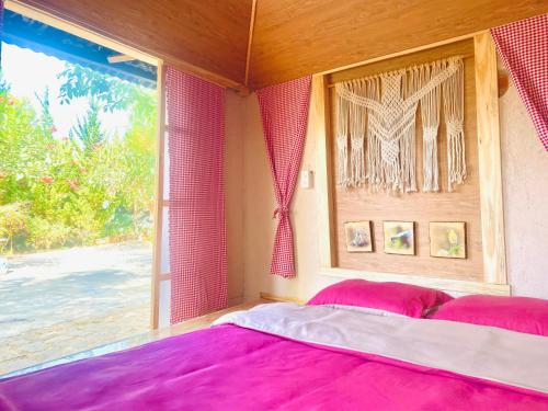 Schlafzimmer mit einem großen Fenster und einem Bett mit rosa Bettwäsche in der Unterkunft Hoàng Gia Trang in Da Lat