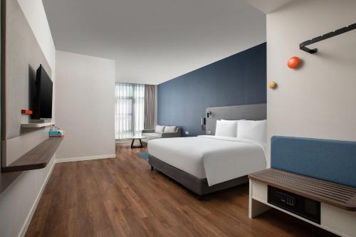um quarto de hotel com uma cama e uma cadeira em Holiday Inn Express Shanghai Tangzhen, an IHG Hotel em Xangai