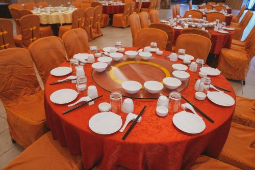 a table with plates and utensils on it in a hall at Roxy Hotel Serian in Serian