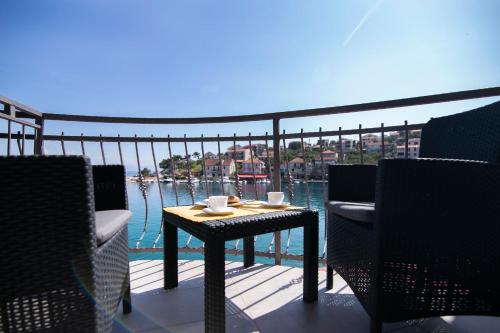 a table on a balcony with a view of the water at Rooms Royal in Stomorska