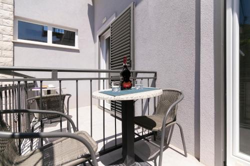 einen Tisch mit einer Flasche Wein auf dem Balkon in der Unterkunft Rooms Royal in Stomorska