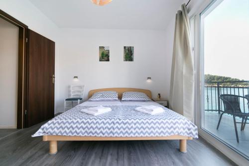a bedroom with a bed and a balcony at Apartments Royal 2 in Stomorska