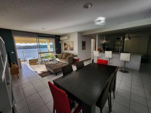 uma sala de jantar e sala de estar com mesa e cadeiras em Magnifique appartement, vue mer em Noumea