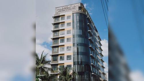 馬尼拉的住宿－麥迪遜塔樓101酒店，一座高大的建筑,前面有棕榈树