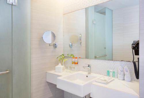 a bathroom with a sink and a mirror at KHAS Tegal Hotel in Tegal