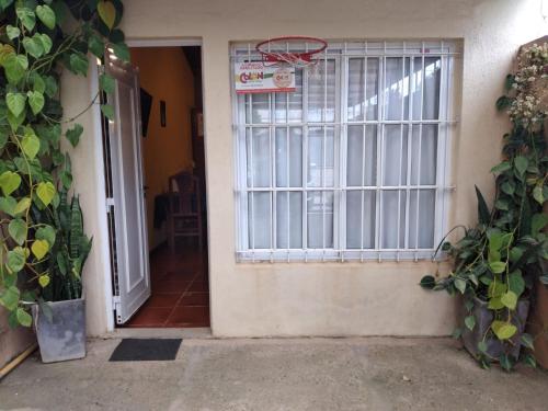 una puerta abierta con un aro de baloncesto al lado de una casa en Alquileres Erramuspe en Colón