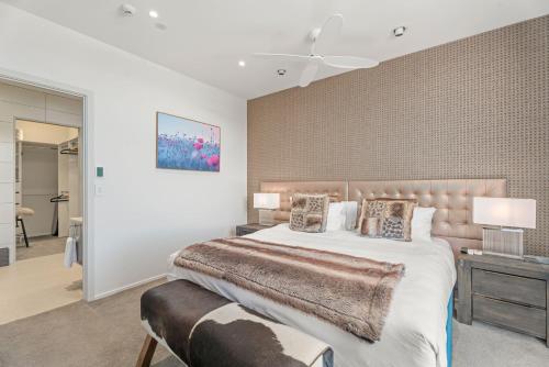a bedroom with a large bed and a wall at Chic Central Penthouse & Spa by Staysouth in Queenstown