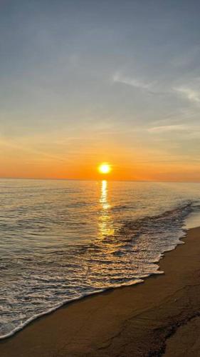 a sunset on a beach with the ocean and the shore at Casa BV: Beautiful new house short walk from beach in Buenavista
