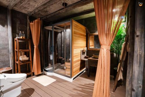 a bathroom with a shower and a toilet and a sink at P'apiu Resort in Ha Giang