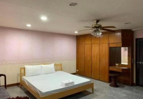 a bedroom with a bed and a ceiling fan at โชคชัยแมนชั่น บางบัวทอง in Nonthaburi