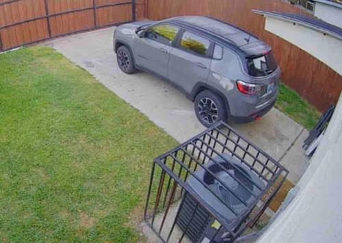 a car parked in a driveway next to a fence at 2 Bedroom Luxury Home.. Wooden Floors and Ceilings in Dallas