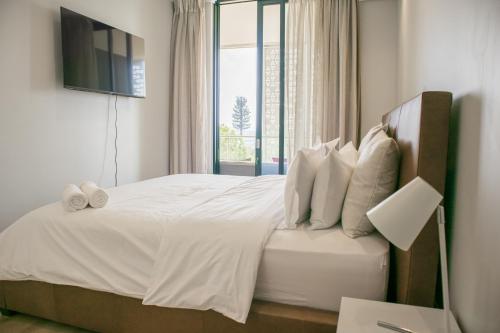 um quarto com uma grande cama branca e uma janela em Thee LuX Ellipse Waterfall em Midrand