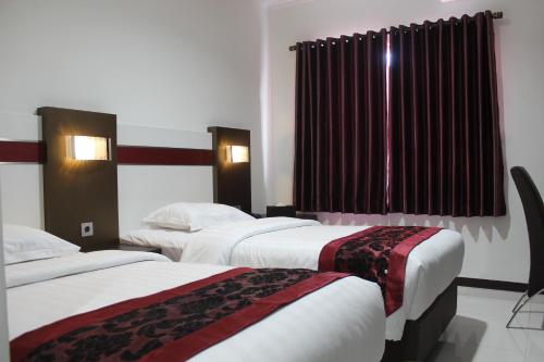 um quarto de hotel com duas camas e uma janela em IDEA's Hotel Jalan Ibrahim Aji em Bandung