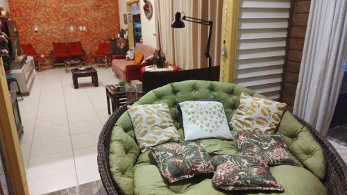 un sofá verde con almohadas en la sala de estar. en Graça de Casa, en Florianópolis