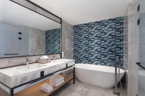 a bathroom with a tub and a large mirror at Fairfield by Marriott Huai'an Downtown in Huai'an