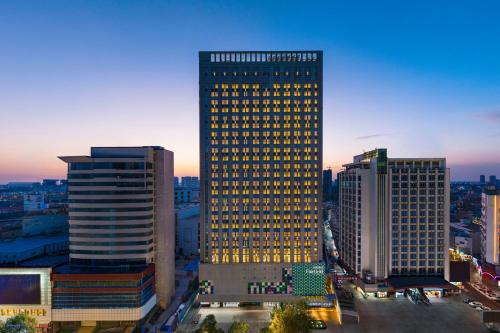 a tall building with yellow lights on it in a city at Fairfield by Marriott Huai'an Downtown in Huai'an