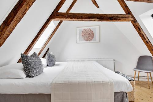 コペンハーゲンにあるSanders Penny - Charming Three-Bedroom Apartment in the Middle of Actionのベッドルーム(白いベッド1台、椅子付)