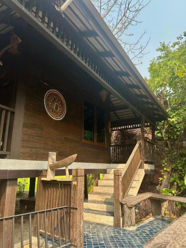 a wooden house with stairs leading to a porch at Bantunglom Resort in Mae Rim